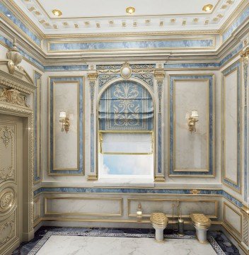 This picture shows a luxurious home interior, featuring a marble staircase with an ornate, gold-plated railing. The walls and floor are covered in white and gray marble tiles, while the ceiling features detailed crown molding. At the top of the stairs is a lounge area with a plush sofa, two armchairs, and a glass-top coffee table. On the walls are beautifully framed abstract pieces of art.