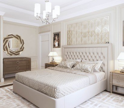 This picture shows a beautiful interior in white, gold, and grey tones. The focal point of the room is an ornately carved dark wooden bed, with intricately patterned bedding and curtains. On either side of the bed are tall white dressers, which feature elegant gold accents. There is a tufted armchair in the corner, and a large mirror hangs on the wall. The grey patterned rug underfoot grounds the room, tying all of the elements together.