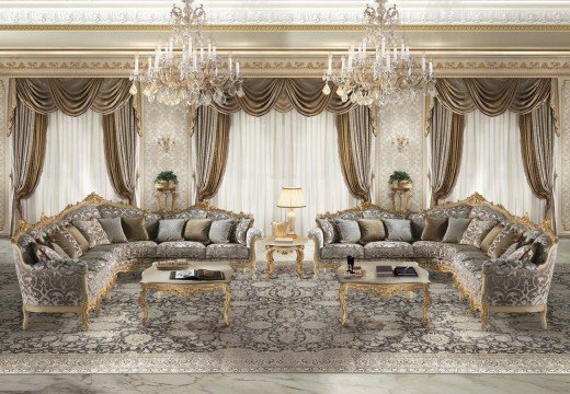 This picture shows a modern, luxurious living room with multiple seating areas. The furniture is predominately white and cream, with some gold accents throughout. There is a large rug in the center of the room, and a crystal chandelier hanging from the ceiling. There are two velvet armchairs and a velvet couch on one side, with a round glass table between them. On the other side, there is a plush white sofa with two matching armchairs around a chic, white coffee table. Light wood floors and walls lined with large windows and sheer drapes add to the elegance of the