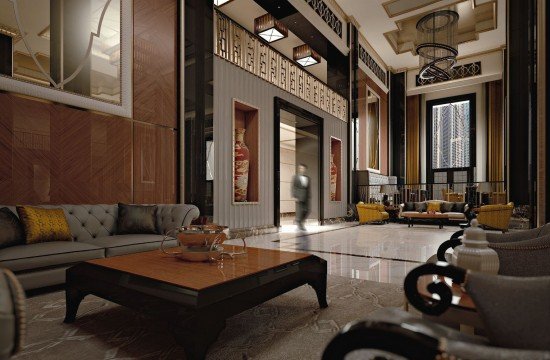 This picture shows a modern luxury living room. The room is decorated in neutral beige, white, and gray tones. There is a large white sofa, two gray chairs, and a gray ottoman in the center of the room. The walls are decorated with a light gray abstract art piece above the sofa as well as a large wall-mounted television. The floor is covered with a beige rug and the room is illuminated with several recessed lighting fixtures. There is also a round glass coffee table in the center of the room.