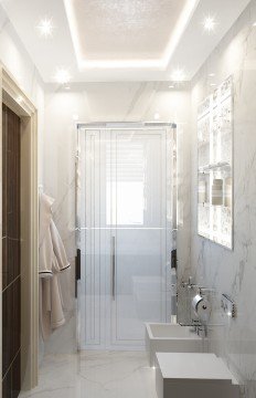 This picture depicts a luxurious bathroom design with modern fixtures and white marble accents. The bathroom features a large walk-in shower, two sinks on either side of the vanity, and a free-standing bathtub in the center. The room is finished in light beige tones, with white marble around the walls and accents of gold on the taps and faucets. There are also recessed lighting fixtures that add a stylish touch to the space.
