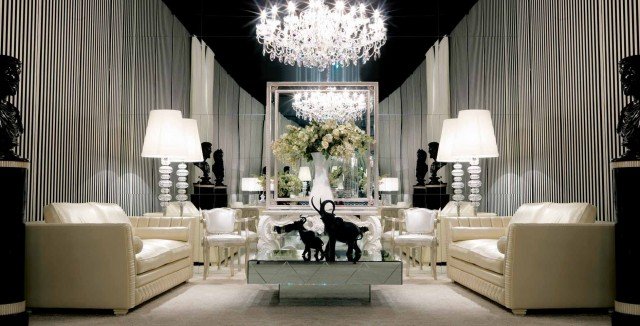This picture is a closeup of an elegant dining room designed by Antonovich Design. It features a striking black and white color scheme, with a marble-topped dining table surrounded by elegant white chairs. The walls are adorned with large, ornate mirrors and the ceiling features intricate moldings and crown molding. In addition, the room has several pendant lights hanging from the ceiling to create a warm, inviting atmosphere.