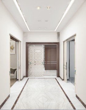 This picture shows a modern, luxury bathroom design. The bathroom has two distinct sections - the shower area on one side and the sink area on the other. The walls and floor are made of cream marble tiles, with gold accent features such as the taps, showerhead, and drain. On the wall separating the two sections is a beautiful ornately patterned mirror surrounded by an opulent gold frame. The lighting in the room is provided by warm recessed lights, and an additional overhead light fixture hangs from the ceiling with a light-colored shade.