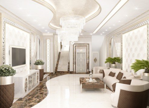 This picture shows an interior design project. It appears to be a luxurious living room with white walls, gold accents and marble flooring. There is a large brown leather sectional sofa and two wooden accent chairs in the center of the room. The walls are accented with art and various decorative lighting fixtures. There is a grand piano in the left corner of the room and a chandelier hanging from the ceiling.