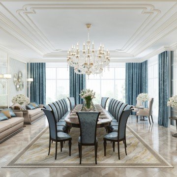 The picture shows a luxurious living room with high ceilings and large statement windows looking out onto a terrace and garden. The room features a grand marble fireplace, an ornately carved wooden chandelier, a white velvet sofa and two armchairs, as well as two glass-topped side tables, a bookshelf, and two gilded mirrors for added elegance. Dark blue walls and pale grey carpeting provide a contrast to the décor and furnishings.