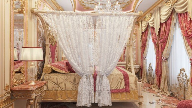 This picture shows a luxurious bedroom interior design. The room has beige walls with white window frames and baseboards. There is a large bed with a tufted headboard and white bedding in the center of the room, flanked by two plush armchairs with matching ottomans. The room also features a large wardrobe with mirrored doors, an oval chandelier with copper accents, and an ornate molding along the walls and ceiling.