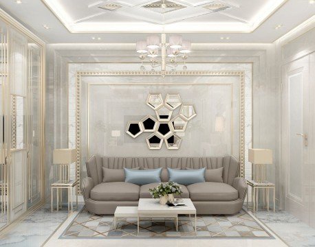 The picture shows a luxurious living room with an ornate, curved ceiling and wall paneling. The walls are predominantly a soft gray color, accented by white and golden yellow patterns and designs. A large, gold-framed mirror is mounted in the center of the wall, and two beige sofas with colorful pillows are situated in the middle of the room. To the side, two chairs with matching footrests and coffee tables create a cozy seating area. A light wood floor completes the elegant aesthetic.