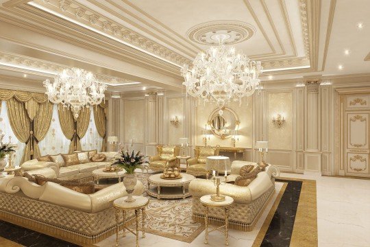 This picture shows an interior design with classical, Baroque-style decor. The walls are painted a light cream color and covered with elegant wallpaper featuring intricate gold and white designs. The furniture is ornate and includes a large sofa, two armchairs and several side tables. The floors are a dark wood and are covered with colorful Persian carpets. There are several chandeliers in the room and several paintings adorn the walls. The room has a very luxurious and opulent feel.