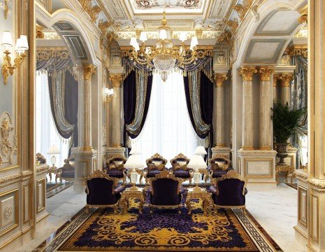 This picture is of an intricately-decorated, luxurious dining area. The walls feature light marble panels with gold accents, and an elaborate chandelier hangs from the ceiling. The floor is covered in a plush white, patterned rug and the dining table is a sleek, dark wood. Various chairs surround the table, all upholstered in a lavish, gold-and-burgundy velvet fabric. The table is dressed with fine dishes and crystal goblets, emphasizing the grand atmosphere of the room.