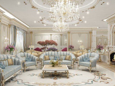 The picture shows a luxurious white and gold dining room. The walls are white with gold accents, and the floor is covered in a beige rug. In the center of the room is a large round dining table with six matching chairs upholstered in a cream fabric. On the table is an ornate crystal chandelier and an arrangement of white lilies and greenery. Above the table is a black wall lamp with gold detailing.