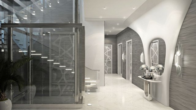 A modern interior featuring a marble-tiled wall, with a framed mirror and sconces mounted on the wall. A built-in shelving unit flanked by tufted chairs is situated in the room.