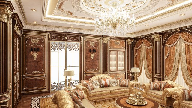 This picture is of a luxurious bedroom designed by Antonovich Design. It has gold and ivory walls, ceiling, and furniture. The room also has a large bed with an ornate headboard and an elegant canopy bed frame. A crystal chandelier hangs from the ceiling, as well as two large wall sconces. There is a patterned rug on the floor and a luxurious armchair in the corner. The windows are covered with heavy curtains, and there are several pieces of art decorating the walls.