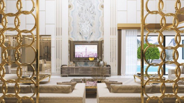 Contemporary luxury living room with high-end furniture pieces, ornate ceiling and wall moldings, fireplace, grand chandelier, and large area rug.