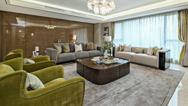 This picture depicts an elegant and luxurious living room with a spectacular view of the city. The room features several pieces of modern furniture that are upholstered in a neutral color scheme, including a white sofa and armchairs, a light brown loveseat and a creamy marble coffee table. There is an impressive wall mirror adorned with a gold frame, as well as a charming rug covering the hardwood floor. The large, open windows provide plenty of natural sunlight and breathtaking views of the city skyline.