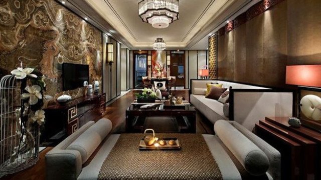 Modern luxury apartment design with marble walls and floor, multi-level ceiling, and decorative furniture.