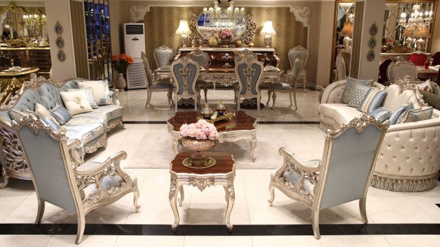 An interior design featuring a luxurious marble floor, cream walls, and a white sofa with ornate fabric upholstery.