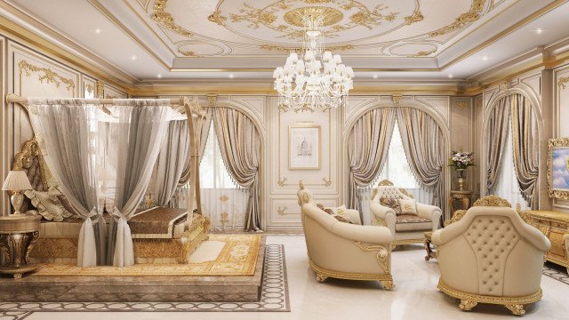 This picture shows a grand and luxurious living room. It has high ceilings with extravagant details such as ceiling mouldings and chandeliers. The walls are painted in a light beige color and the floor is covered with beige marble tiles. The design of the furniture is modern and sophisticated, with white leather armchairs and a large white sofa with black and gold cushions. There is an ornate rug in the center of the room with intricate patterns in shades of gold and brown. The overall atmosphere of the room is one of opulence and luxury.