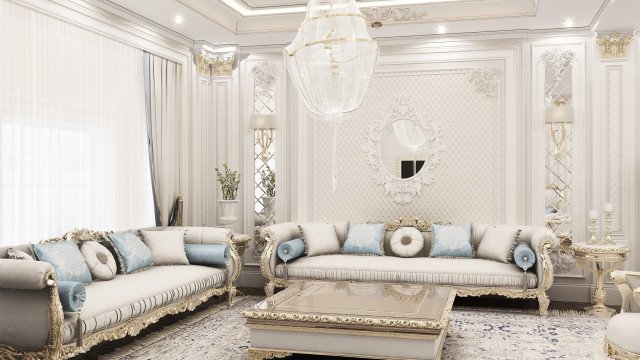 This picture is a rendering of an interior space in a luxurious home designed by Antonovich Design. It is a modern living room that features a beige stone accent wall, white sofa and chairs, and a glass coffee table. The room also has a well-lit ceiling with a beautiful chandelier and intricate molding. There is also a cozy fireplace with built-in shelves that display a collection of books and artifacts. The space is finished off with an abstract rug and a vibrant painting on one of the walls.
