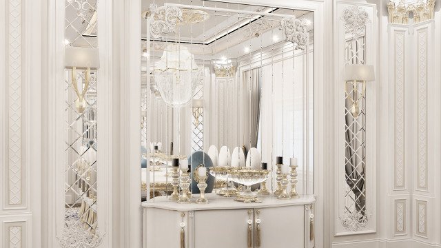 This picture is of a luxurious bedroom interior design inside a home. It consists of light-colored walls and dark brown ceiling with a beautiful crystal chandelier hanging from the center. The furniture consists of a grand tufted bed with white and gold accents, two ornate chairs, and a mirrored nightstand with lights. The room is decorated with a silver damask patterned wallpaper, plush carpeting, and lush sheer curtains framing the windows.