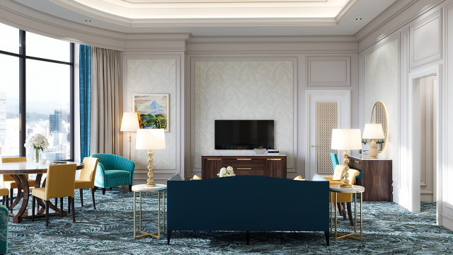 This image shows a modern living room space designed by Antonovich Design. The room features an elegant white and silvery grey color palette and sleek, clean lines. There is a large sectional sofa upholstered in a white fabric, two armchairs and a glass coffee table. In the background, there are also built-in shelves with a variety of decorative items, including vases, books, and plants. The room is illuminated by a large ceiling light, as well as several smaller wall lamps.