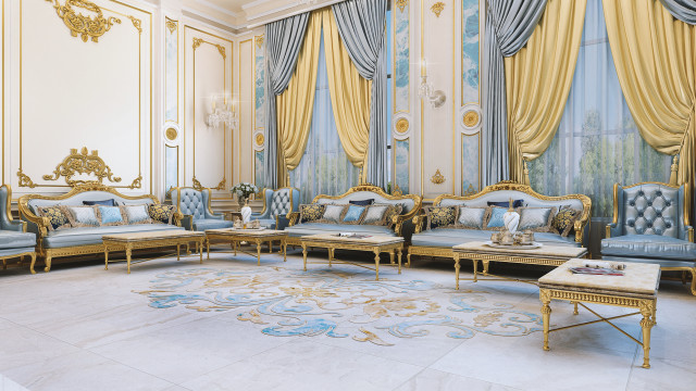 This picture shows a modern and luxurious living room designed by Antonovich Design, an elite global design firm. The walls and ceiling are covered in ornate white paneling, which is illuminated by an array of recessed lighting. In the center of the room is a large, round white sofa with several matching armchairs arranged around it, while in the corner there is a unique, brown circular table with a glass top. A contemporary chandelier hangs from the ceiling, adding a touch of elegance to the space.