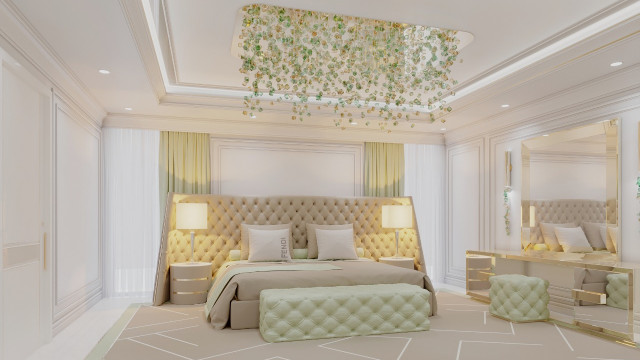 This picture shows a luxurious master bedroom space with high ceilings and abundant natural light. The room includes a king-size bed in the center, two nightstands on either side, and tall vertical windows that let in plenty of sunshine. The walls feature textured cream and beige wallpaper, and an elegant chandelier hangs from the ceiling. To one side is a comfortable seating area with a velvet bench and armchairs for relaxation.
