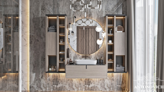 This picture shows a stunning marble bathroom with a floating vanity and two wall-mounted sinks. The walls of the bathroom are covered in luxurious white marble tiles and the floor is laid with a black and white marble pattern. There is also a beautiful, modern chandelier hung above the vanity, as well as a large mirror on the wall above the sinks.