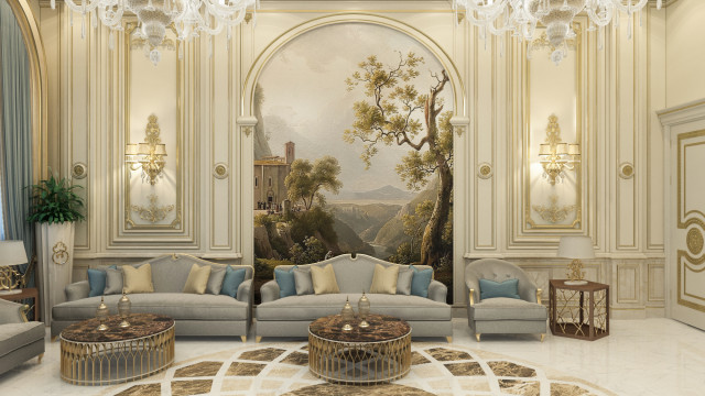This picture shows an elegant, modern living room with a view of a swimming pool outside the windows. The room is done in neutral colors, with white and grey walls, light hardwood flooring, and modern furniture pieces such as a velvet blue sofa and armchair, a white tufted ottoman, and a round wooden coffee table. There are also several potted plants on the windowsill and a large framed painting on the wall above the sofa.