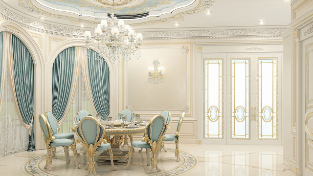 This picture shows a luxurious dining room with a statement marble table and seating. The room also has a large beige sofa, two ornate chandeliers, and floor-to-ceiling light grey curtains. The walls feature decorative paneling and an abstract painting. Finally, the room is accented by a golden wall mirror with a curved frame.