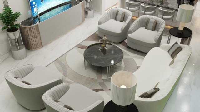 This picture shows a luxurious living room with modern, white furniture and bright accents. The room is decorated with an ornate wall mirror, and a chandelier hangs from the ceiling. The walls are a light neutral color and have some framed artwork on them. There is a large white leather sofa with matching chairs and footrest, and a glass coffee table in the middle. There are also several standing lamps throughout the room and a rug on the floor to help complete the look.