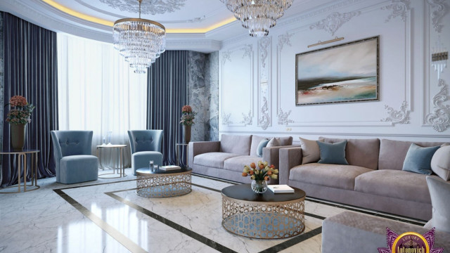 This picture shows a luxurious modern living space with monochrome color scheme. The space features a cream-colored couch and armchair, a gray shag rug, a white coffee table and two black end tables. The walls are painted a light gray color and adorned with black and white art prints. There is also a fireplace in the corner with black marble surrounding it.