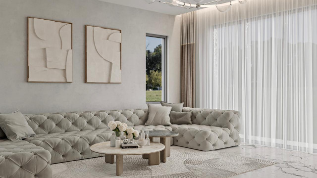 This picture shows a luxurious modern living room designed by Antonovich Design. It features a large plush white sectional sofa with bright pink and black throw pillows, an elegant gold and white coffee table, and a decorative black accent wall with a gold mirror and fireplace. The room is finished off with a large chandelier and a stylish area rug.