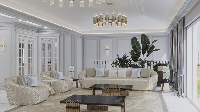 This picture shows a luxurious modern living room designed by Antonovich Design. The room features a grand marble fireplace with a large framed mirror above it and a gold chandelier. The walls are painted in a neutral color and adorned with decorative panels. There is a sofa upholstered in a white fabric and various accent chairs, as well as several occasional tables, a large wood coffee table, and an area rug in shades of grey, brown, and beige.