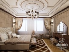 Luxury bedroom, with a lot of gold details, white furnishings and a gorgeous green armchair. Perfect to create a royal atmosphere.