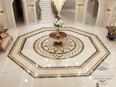 A unique, modern hallway with a luxurious marble floor, accentuated by a chandelier lit up to complete the regal interior design.