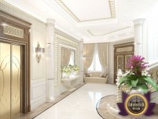 This image shows a gorgeous white and golden living room with high ceilings, luxurious furniture and modern design.