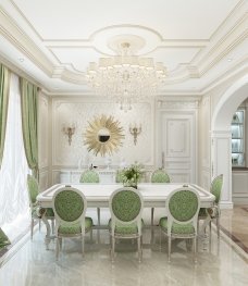 This picture shows a contemporary dining room with an open concept and a light, neutral color palette. The furniture includes a large rectangular dining table topped with a beige marble slab, set against a backdrop of white walls, cream-colored flooring, and a modern abstract-patterned area rug. On the left side of the room is a seating area consisting of two white armchairs and a tufted sofa, both with matching ivory and brown patterned cushions. On the right side of the room is a bar cart with bottles of liquor and stemware for entertaining. A modern gold