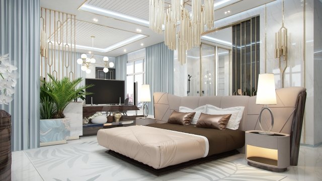 This is a picture of a luxurious, modern bedroom featuring grey carpeting, a light grey and white accent wall, and a beige sofa with matching pillows. On the wall behind the sofa hang round mirrors and a flat-screen television, while a large glass chandelier hangs from the ceiling and adds a touch of glamour to the room.