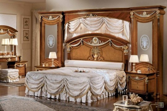 Luxury interior design of a modern classic bedroom with gold walls, grand chandelier and perfect furniture.