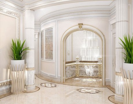 This picture shows an ornately decorated hallway with a marble and tile floor, a mirrored wall, and a gold-plated door and trim. The intricate details of the moldings, marble tiles, and golden accents are illuminated by two unique wall sconces, creating a dramatic, luxurious atmosphere.