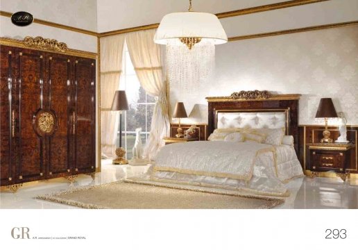 This picture shows a luxury bedroom suite. The bedroom is decorated in light pastel colors, giving it a warm and inviting atmosphere. The bed is dressed with multiple pillows and a beautiful comforter. There is a nightstand beside the bed, with a lamp and a vase of flowers. On the opposite side of the room is a set of French doors that open onto a balcony. The walls are adorned with elegant wallpaper and artwork.