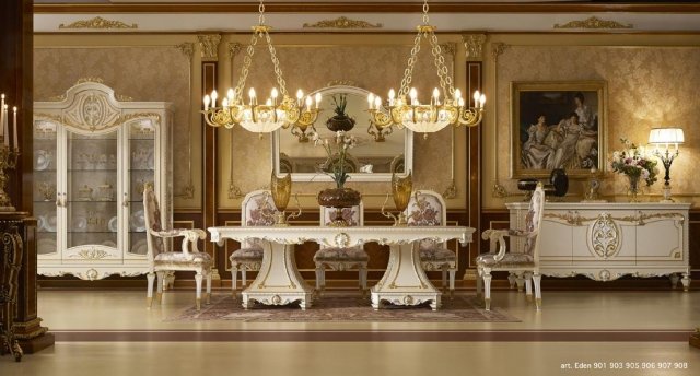 This picture shows a luxurious interior design with marble flooring and an exquisite chandelier hanging from the ceiling. The furniture is composed of two white sofas, two armchairs with gold accents, and two white tables with glass tops. To the side is a grand fireplace with two sconces and above sits an ornate gold mirror. Rich fabrics drape from the windows, completing the luxurious feel of the room.